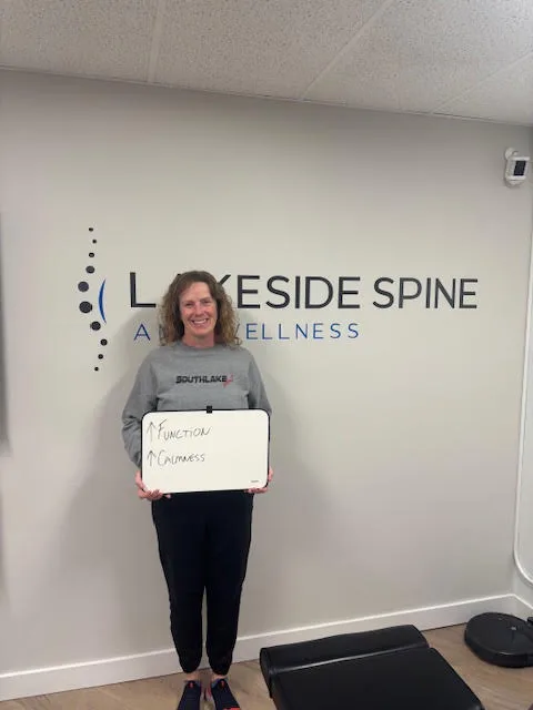 Lakeside Spine and Wellness patient holding a whiteboard reading function up, calmness up